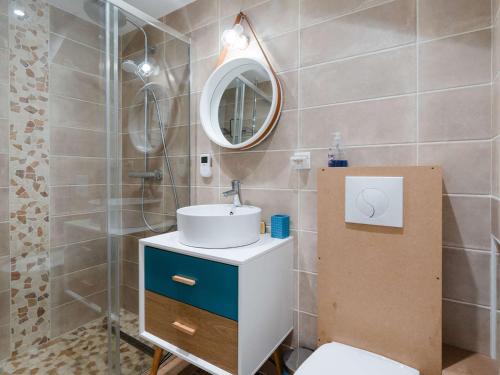 une salle de bain avec un lavabo et un miroir dans l'établissement Appartement T3 climatisé, rénové avec goût, à 150m de la plage, avec terrasse et équipements complets - FR-1-409-204, à Fleury