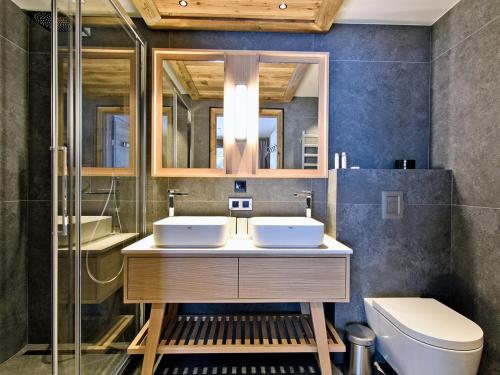a bathroom with two sinks and a toilet at Appartement Luxe Méribel avec Spa et Terrasse - FR-1-613-59 in Les Allues