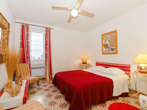- une chambre avec un lit rouge et un ventilateur de plafond dans l'établissement Appartement Spacieux dans Domaine Viticole à 2 km de Narbonne-Plage, 3 Chambres, Accès WiFi Inclus - FR-1-409-180, à Narbonne