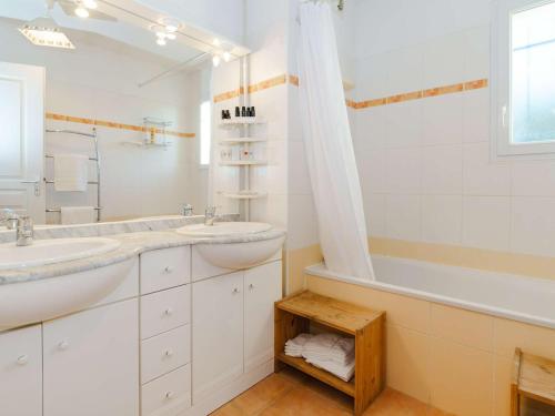 Baño blanco con 2 lavabos y bañera en Appartement Narbonne-Narbonne Plage-Narbonne Plage, 3 pièces, 4 personnes - FR-1-409-181, en Narbona