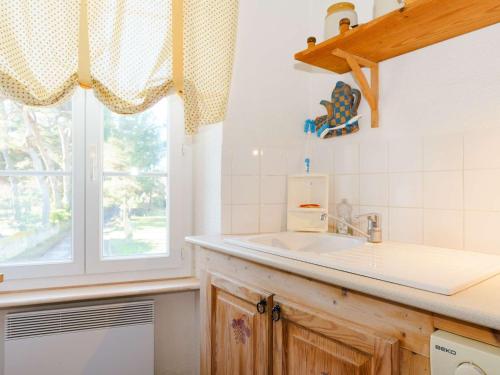 une cuisine avec un évier et une fenêtre dans l'établissement Appartement Spacieux dans Domaine Viticole à 2 km de Narbonne-Plage, 3 Chambres, Accès WiFi Inclus - FR-1-409-180, à Narbonne