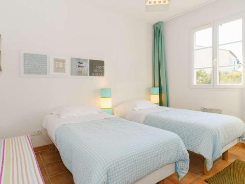 2 camas en una habitación blanca con ventana en Appartement Narbonne-Narbonne Plage-Narbonne Plage, 3 pièces, 4 personnes - FR-1-409-181, en Narbona