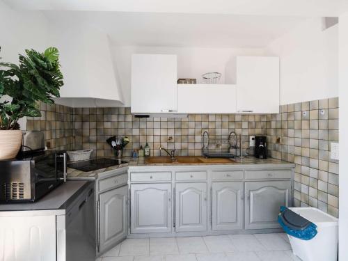 une cuisine avec des armoires blanches et un évier dans l'établissement Villa familiale spacieuse à Narbonne-Plage pour 6 pers, parking privé, animaux admis - FR-1-409-194, à Narbonne