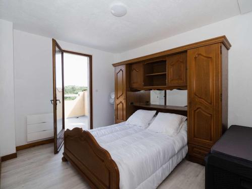 - une chambre avec un grand lit et une armoire en bois dans l'établissement Villa familiale spacieuse à Narbonne-Plage pour 6 pers, parking privé, animaux admis - FR-1-409-194, à Narbonne