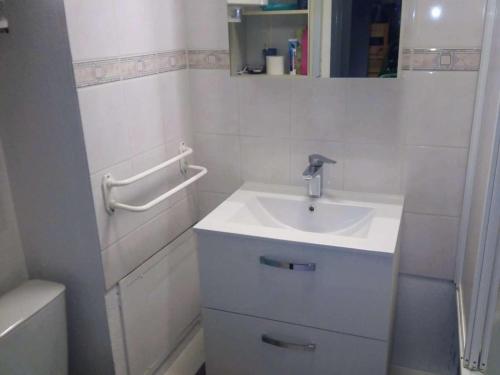 La salle de bains blanche est pourvue d'un lavabo et d'une baignoire. dans l'établissement Studio cabine avec piscine et vue port à Gruissan - FR-1-409-199, à Gruissan