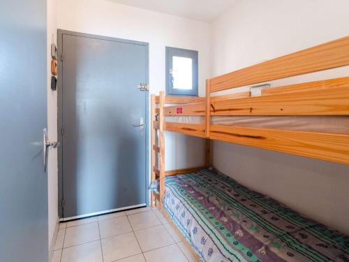 Cette chambre comprend 2 lits superposés et une porte. dans l'établissement Studio cabine avec piscine et vue port à Gruissan - FR-1-409-199, à Gruissan