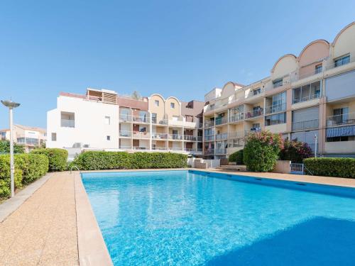 - une piscine en face d'un immeuble dans l'établissement Studio cabine avec piscine et vue port à Gruissan - FR-1-409-199, à Gruissan