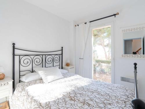 une chambre blanche avec un lit et une fenêtre dans l'établissement Duplex cosy avec piscine et WiFi, proche plage et commerces, pour 4 pers., parking inclus - FR-1-409-213, à Fleury