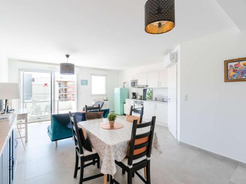 une cuisine et une salle à manger avec une table et des chaises dans l'établissement T3 climatisé, proche plage, neuf, WIFI inclus, parking privé - FR-1-409-230, à Narbonne