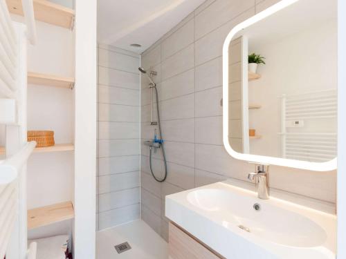 une salle de bain blanche avec un lavabo et un miroir dans l'établissement Pavillon climatisé, rénové, piscine, proche plage, parking privé, animaux acceptés - Gruissan - FR-1-409-218, à Gruissan