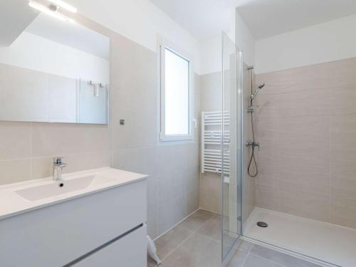 une salle de bain blanche avec un lavabo et une douche dans l'établissement T3 climatisé, proche plage, neuf, WIFI inclus, parking privé - FR-1-409-230, à Narbonne