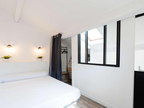 une chambre avec un lit blanc et une fenêtre dans l'établissement Pavillon climatisé, rénové, piscine, proche plage, parking privé, animaux acceptés - Gruissan - FR-1-409-218, à Gruissan