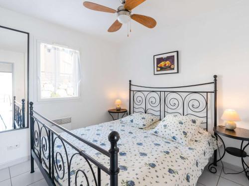 une chambre avec un lit et un ventilateur de plafond dans l'établissement T3 avec piscine, terrasse vue mer et parking privé - FR-1-409-219, à Fleury