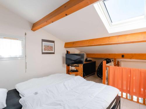 une chambre avec un lit et une lucarne dans l'établissement Pavillon Studio Mezzanine Climatisé avec Piscine et WIFI, Proche Plage à Gruissan - FR-1-409-240, à Gruissan
