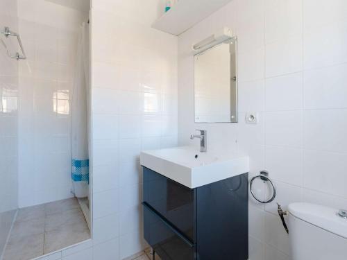 un bagno bianco con lavandino e specchio di Pavillon Confortable avec Piscine, Terrasse et Parking Privé - FR-1-409-220 a Fleury
