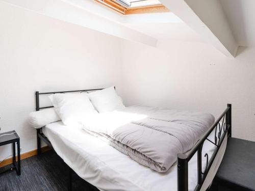 uma cama com lençóis brancos e almofadas num quarto em Appartement Narbonne, 2 pièces, 6 personnes - FR-1-409-243 em Narbona