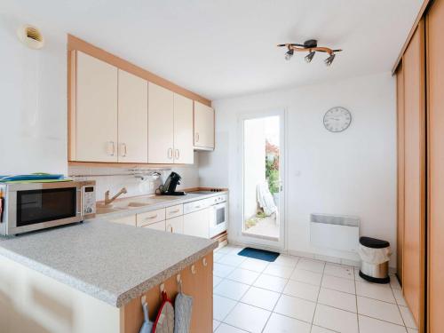 une cuisine avec des armoires blanches et un comptoir dans l'établissement Pavillon 3 pièces avec piscine et parking proche plages - FR-1-409-226, à Fleury