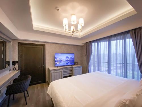 a hotel room with a bed and a television at DAMNERNPAWA in Bang Khon Thi