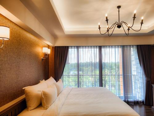 a bedroom with a bed and a large window at DAMNERNPAWA in Bang Khon Thi