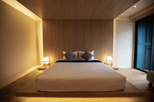 a bedroom with a large white bed with two lamps at The Arch Phuket Hotel in Ban Ket Ho