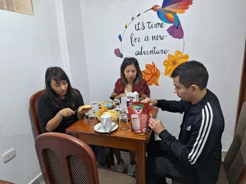 um grupo de pessoas sentadas à mesa a comer em CUSI QOYLLOR em Machu Picchu