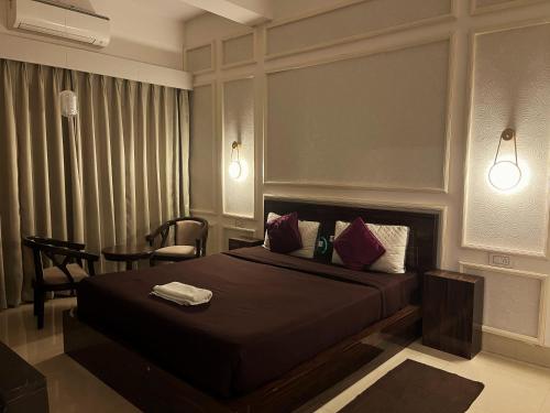 a bedroom with a bed and a chair and a table at Alhanney Housing in Guwahati