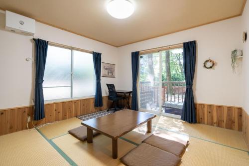 a living room with a table and a window at S-villa Nasu 8th in Nasu