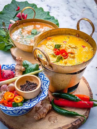 a table with two large pots of food and vegetables at DAMNERNPAWA in Bang Khon Thi