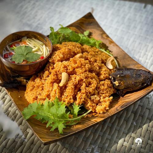 a plate of food with fried food and a bowl of vegetables at DAMNERNPAWA in Bang Khon Thi