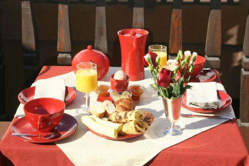 un tavolo con una tovaglia rossa con cibo e bevande di Riad Mille Et Une Nuits a Marrakech