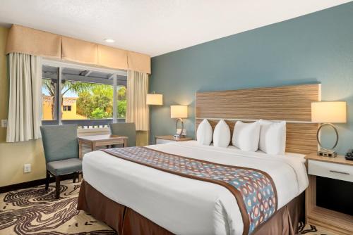 サンルイス・オビスポにあるAvenue Inn Downtown San Luis Obispoの大きなベッドとデスクが備わるホテルルームです。