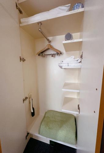 a walk in shower with a green bench in a room at Nissei Hotel Fukuoka in Fukuoka