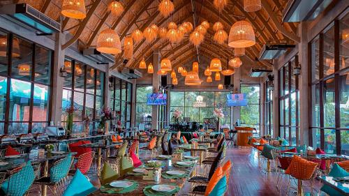 a restaurant with tables and chairs and chandeliers at DAMNERNPAWA in Bang Khon Thi