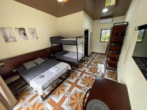 a small room with two beds and a table at POSADA MIRADIA in Matapalo