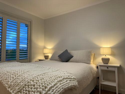1 dormitorio con cama blanca y ventana en PepperTree Farm Stay en Grassy