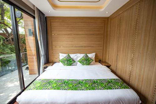 a bedroom with a large bed with a large window at DAMNERNPAWA in Bang Khon Thi
