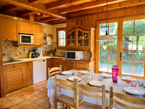 une cuisine avec une table et des chaises dans une cuisine dans l'établissement Chalet familial proche des pistes avec WiFi et parking - FR-1-623-349, aux Gets