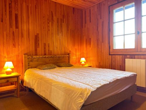 - une chambre dotée d'un lit avec des murs en bois et 2 lampes dans l'établissement Chalet familial proche des pistes avec WiFi et parking - FR-1-623-349, aux Gets