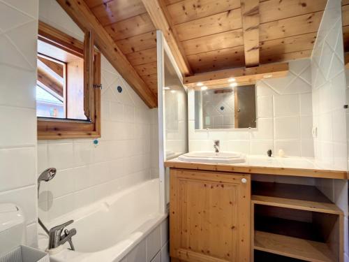 un bagno con lavandino, vasca e WC di Chalet rénové avec jacuzzi, cheminée et terrasse à Méribel - FR-1-688-64 a Méribel