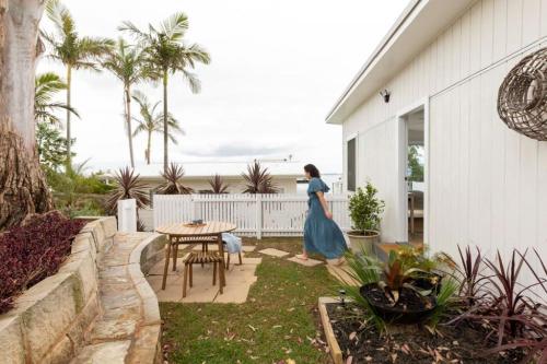 a woman in a blue dress standing on a patio at The Bunkie @ Ethel & Odes in Bundeena