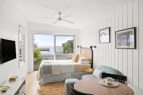 a bedroom with a bed and a table in a room at The Bunkie @ Ethel & Odes in Bundeena