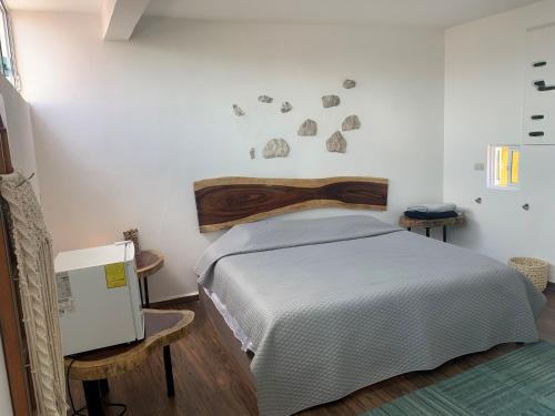ein Schlafzimmer mit einem Bett mit einem Kopfteil aus Holz in der Unterkunft hermoso departamento en coatepec in Coatepec