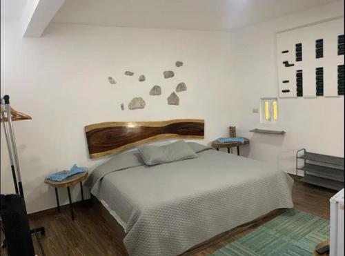 1 Schlafzimmer mit einem weißen Bett und 2 Tischen in der Unterkunft hermoso departamento en coatepec in Coatepec