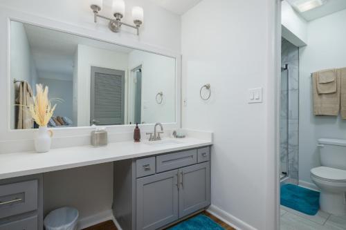 ein Badezimmer mit einem Waschbecken, einem Spiegel und einem WC in der Unterkunft Quick Escape, A Great Get Away! in Huntsville