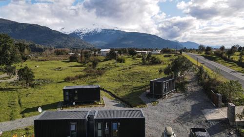 an aerial view of two cabins in a field with a mountain at Puerta austral in Puelo