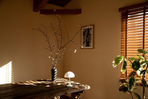a table with a vase with a plant on it at Lodge Norheim in Asahikawa