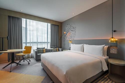 a hotel room with a large bed and a desk at Holiday Inn Johor Bahru City Centre by IHG in Johor Bahru