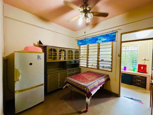 a kitchen with a refrigerator and a table in it at HM AIRBNB in Sibu