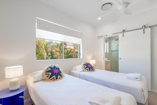um quarto com 2 camas e uma janela em Clearwater Noosa Resort em Noosaville