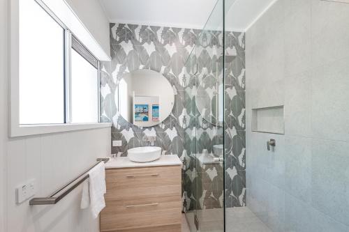 a bathroom with a shower and a sink and a mirror at Clearwater Noosa Resort in Noosaville